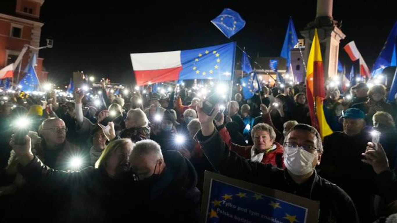 Menschen halten während einer Demonstration in Warschau die Taschenlampen ihrer Mobiltelefone hoch.