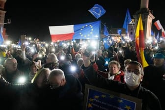 Menschen halten während einer Demonstration in Warschau die Taschenlampen ihrer Mobiltelefone hoch.