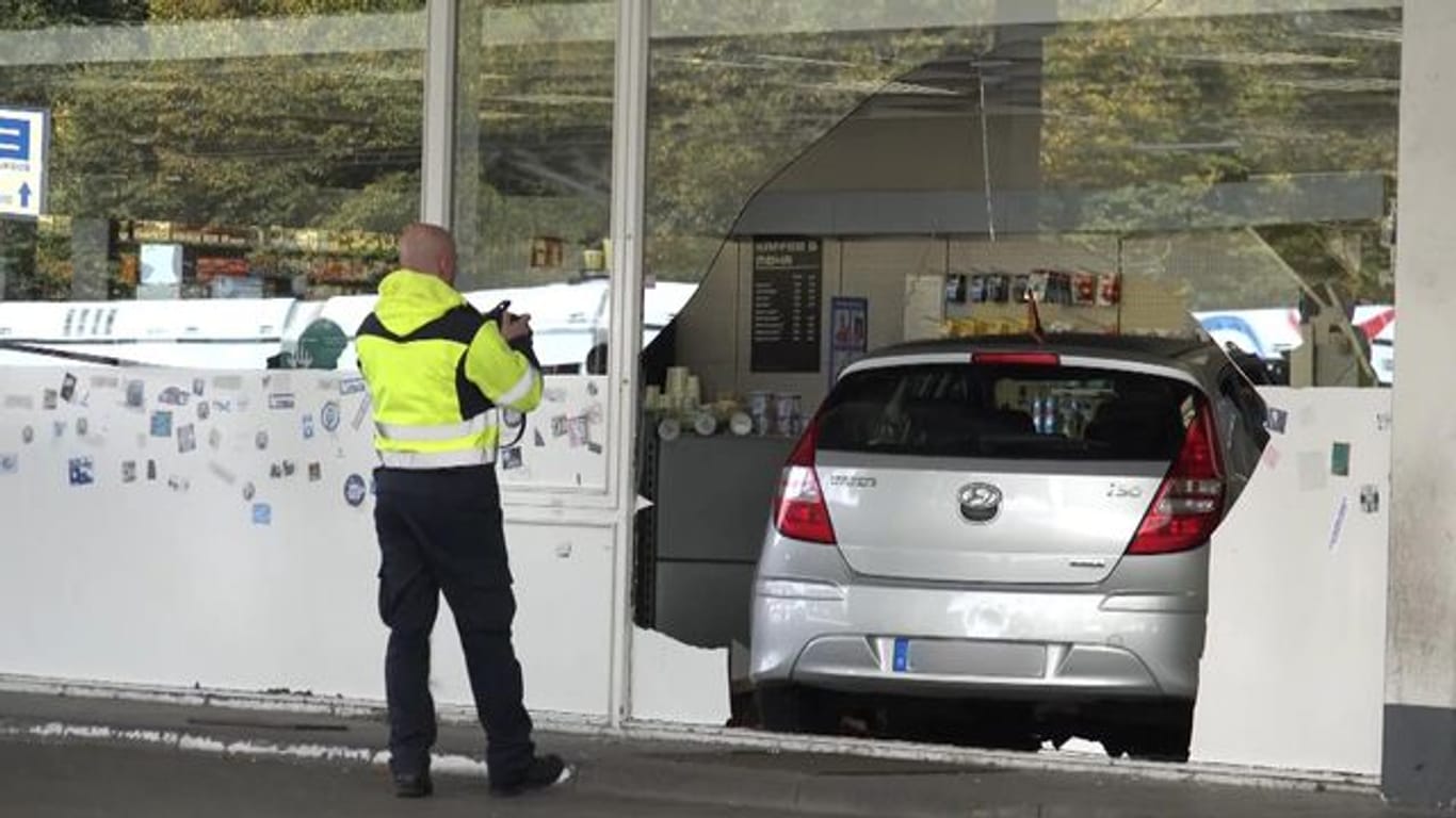 Fassade durchbrochen: Das Auto, gesteuert von einem kleinen Jungen, steht in einer Tankstelle in Bochum.