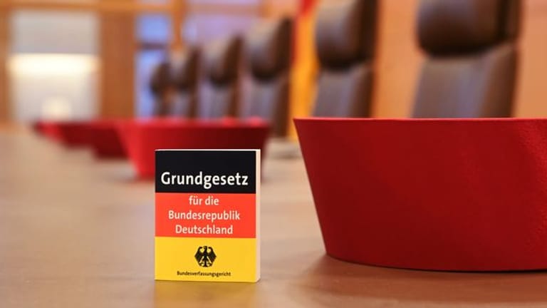 Auf der Richterbank im Sitzungssaal im Bundesverfassungsgericht liegen Barette der Bundesverfassungsrichter des ersten Senats.