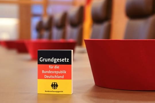 Auf der Richterbank im Sitzungssaal im Bundesverfassungsgericht liegen Barette der Bundesverfassungsrichter des ersten Senats.