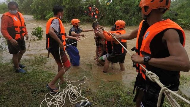 Rettungskräfte in Cagayan helfen während einer Evakuierung einem Kind. Rettungskräfte in Cagayan helfen während einer Evakuierung einem Kind.