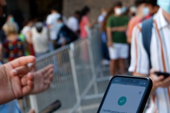 Ein Tourist zeigt am Eingang zu den Vatikanischen Museen seinen "Grünem Pass" vor.