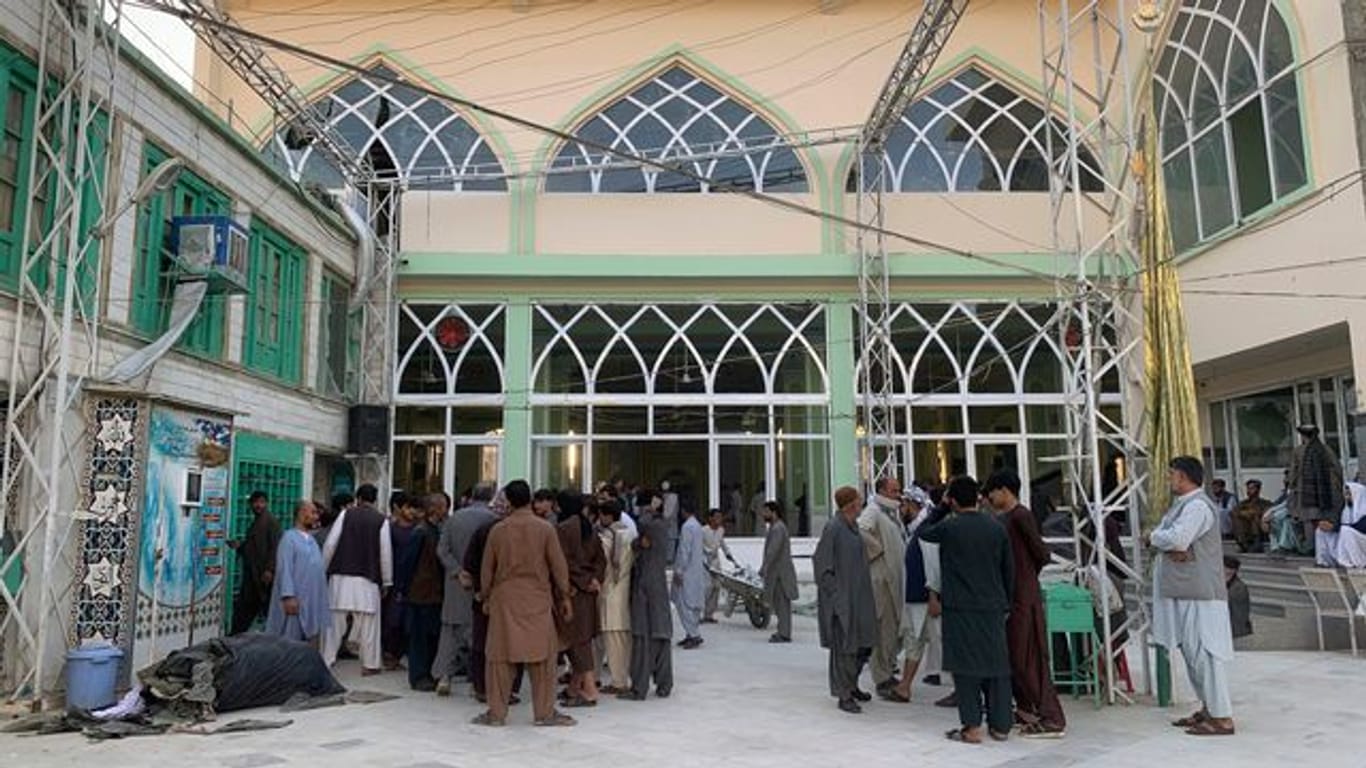 Menschen stehen nach der Explosion in einer Moschee zusammen.