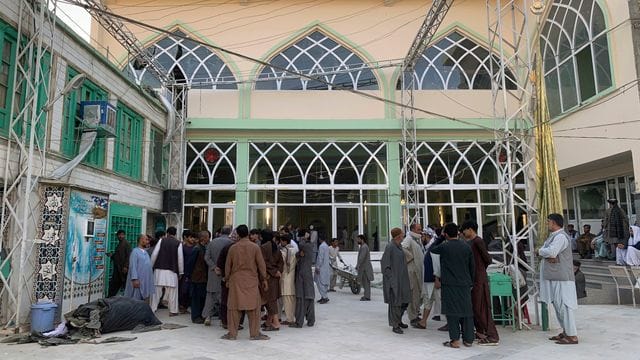 Menschen stehen nach der Explosion in einer Moschee zusammen.