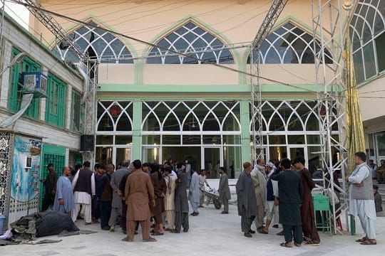 Menschen stehen nach der Explosion in einer Moschee zusammen.