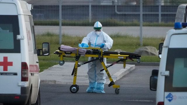 Ein medizinischer Mitarbeiter bereitet eine Trage vor einem Krankenhaus in Kommunarka vor. Ein medizinischer Mitarbeiter bereitet eine Trage vor einem Krankenhaus in Kommunarka vor.