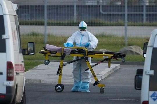 Ein medizinischer Mitarbeiter bereitet eine Trage vor einem Krankenhaus in Kommunarka vor.