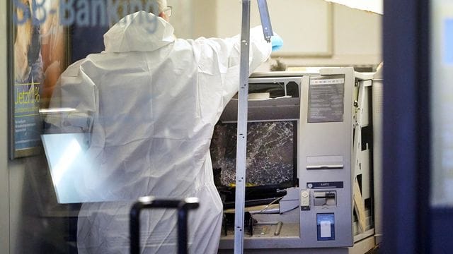 Kripobeamte sichern nach der Sprengung eines Geldautomaten Spuren. Kripobeamte sichern nach der Sprengung eines Geldautomaten Spuren.