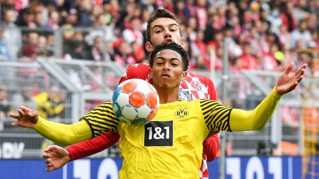 Dortmunds Mittelfeldspieler Jude Bellingham schirmt den Ball geschickt mit dem eigenen Körper vor dem Mainzer Stefan Bell ab. Dortmunds Mittelfeldspieler Jude Bellingham schirmt den Ball geschickt mit dem eigenen Körper vor dem Mainzer Stefan Bell ab.