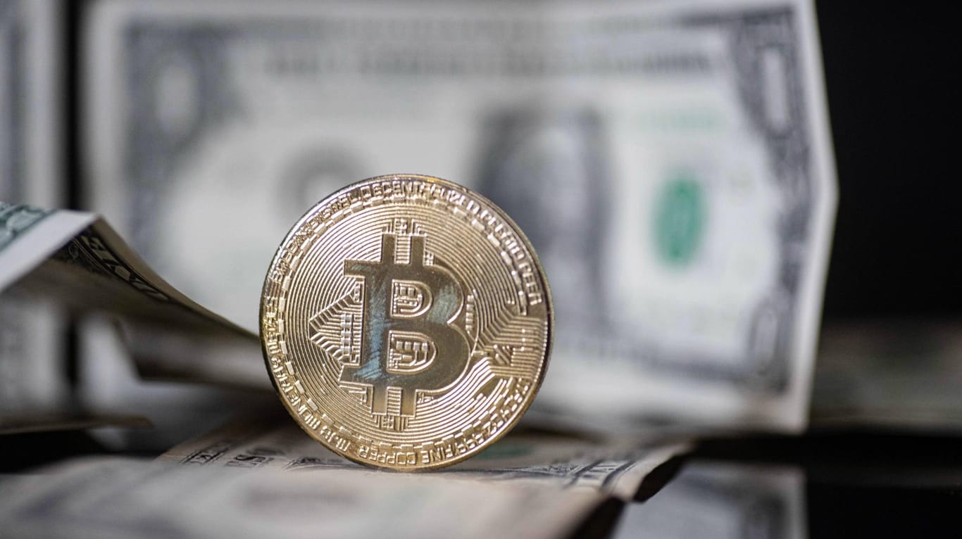 Bitcoin-Münze vor Dollar-Scheinen: Neue Impulse aus den USA lassen den Bitcoin-Preis wieder an seinem bisherigen Allzeithoch kratzen.