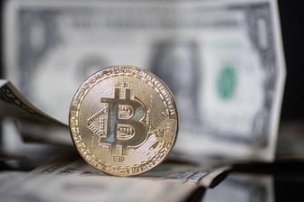 Bitcoin-Münze vor Dollar-Scheinen: Neue Impulse aus den USA lassen den Bitcoin-Preis wieder an seinem bisherigen Allzeithoch kratzen.