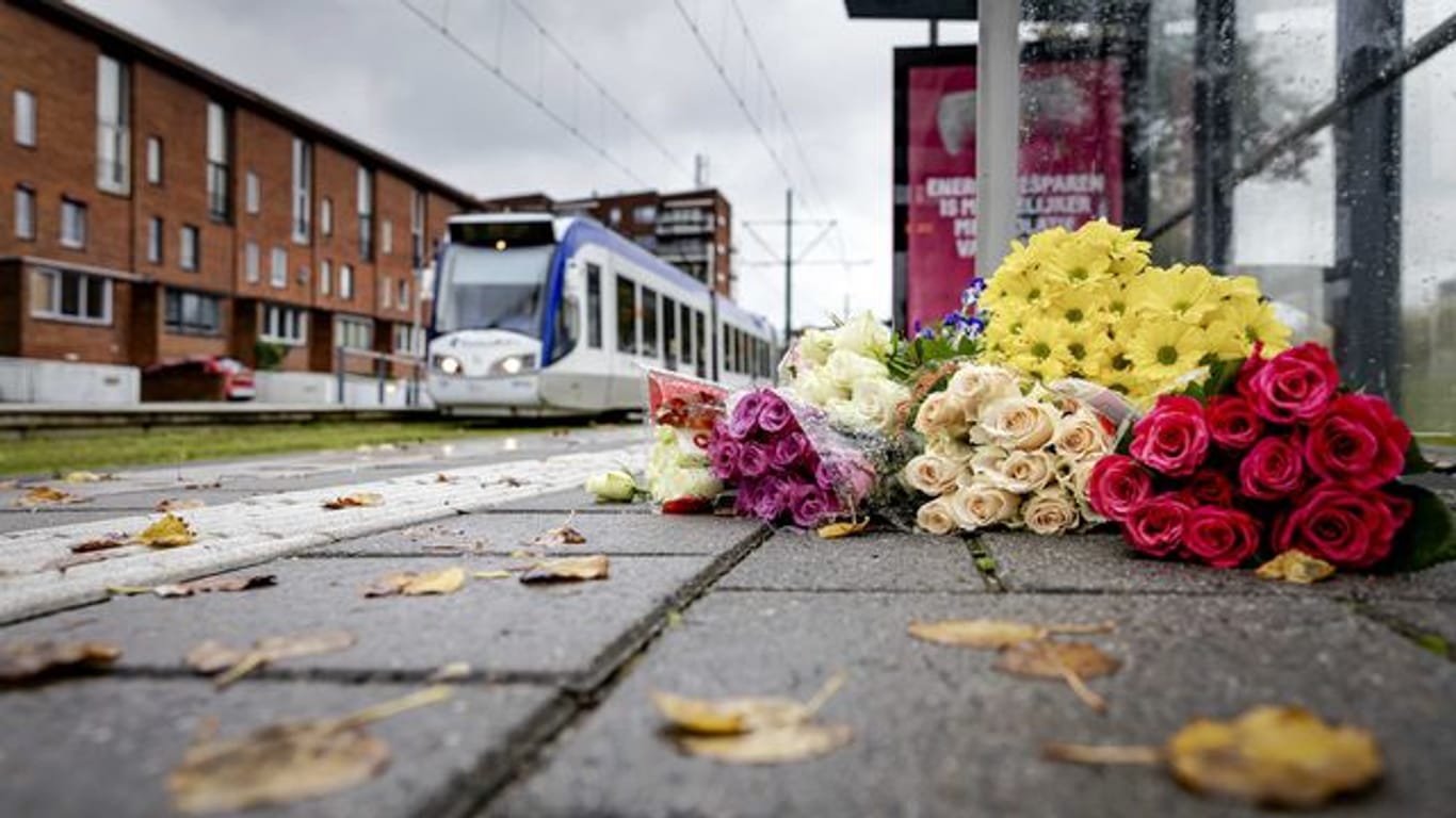 Blumen liegen an der Straßenbahnhaltestelle in Den Haag, wo Jugendliche einen Obdachlosen vor eine Straßenbahn gestoßen und so seinen Tod verschuldet haben.