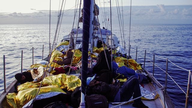 Menschen liegen in Rettungsdecken gehüllt an Bord der "Nadir".