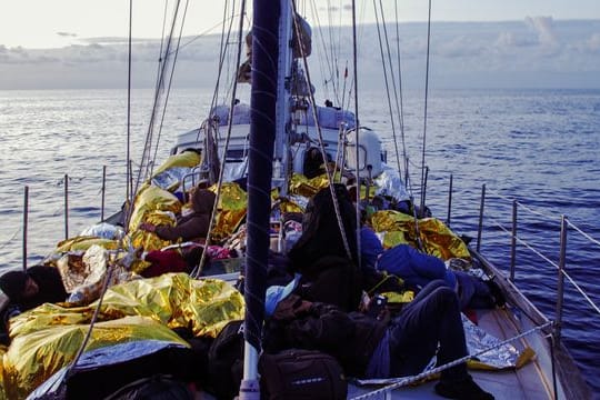 Menschen liegen in Rettungsdecken gehüllt an Bord der "Nadir".