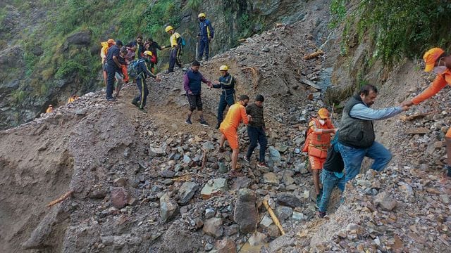 Mitarbeiter der nationalen Katastrophenschutztruppe in Indien bei der Rettung von Zivilisten, die nach schweren Regenfällen im Dorf Chhara gestrandet sind. Mitarbeiter der nationalen Katastrophenschutztruppe in Indien bei der Rettung von Zivilisten, die nach schweren Regenfällen im Dorf Chhara gestrandet sind.