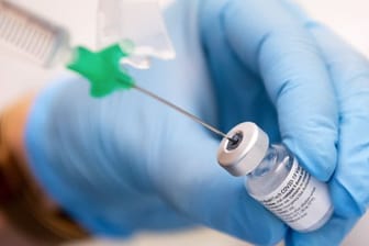 Eine Klinik-Mitarbeiterin zieht den Covid-19 Impfstoff von Biontech/Pfizer auf eine Spritze.
