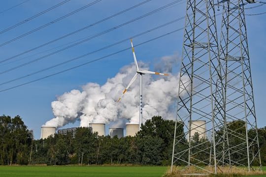 Wasserdampf steigt aus den Kühltürmen eines Braunkohlekraftwerk.