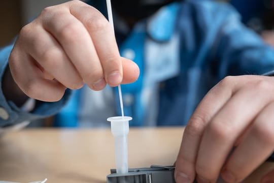 Ein Schüler führt an einer Schule einen Corona-Schnelltest durch.
