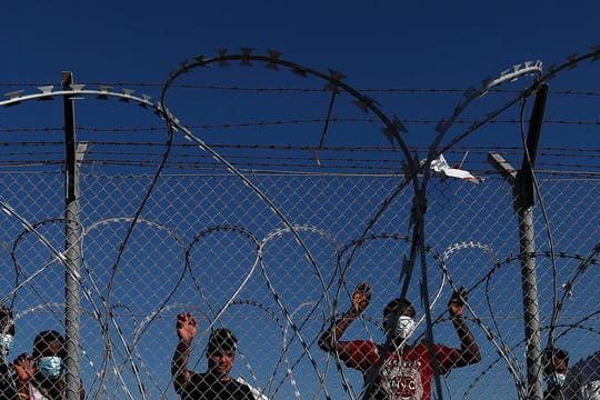 Migranten stehen hinter einem Zaun in einem Flüchtlingslager in Kokkinotrimithia außerhalb Zyperns Hauptstadt Nikosia.