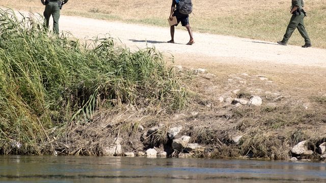 US-Grenzschutzbeamte sprechen mit einem haitianischen Migranten, der von Ciudad Acuna, Mexiko, in die USA eingereist ist.