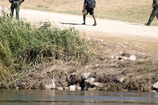 US-Grenzschutzbeamte sprechen mit einem haitianischen Migranten, der von Ciudad Acuna, Mexiko, in die USA eingereist ist.