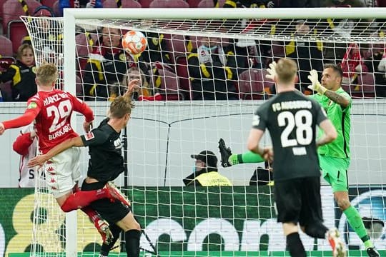 Jonathan Burkardt (l) köpft den Ball zum 3:0 ins Tor von Augsburgs Torwart Rafal Gikiewicz (r).