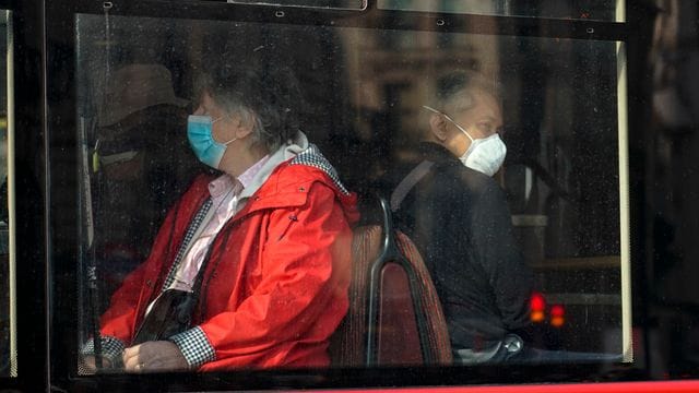 In einem Bus in London tragen Passanten eine Maske. In einem Bus in London tragen Passanten eine Maske.