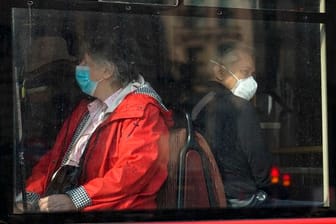 In einem Bus in London tragen Passanten eine Maske.