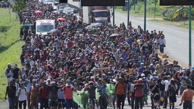 Eine Karawane von Migranten zieht auf einer Küstenstraße in Mexiko in Richtung Norden.