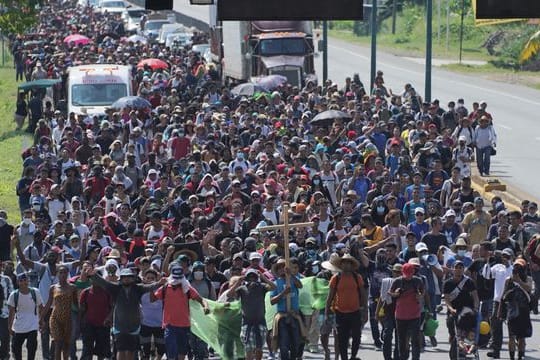 Eine Karawane von Migranten zieht auf einer Küstenstraße in Mexiko in Richtung Norden.