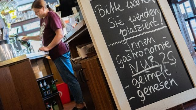 Eine Tafel mit der Aufschrift "Innengastronomie - Nur 2G - geimpft - genesen" steht in einem Gasthaus in Braunschweig.