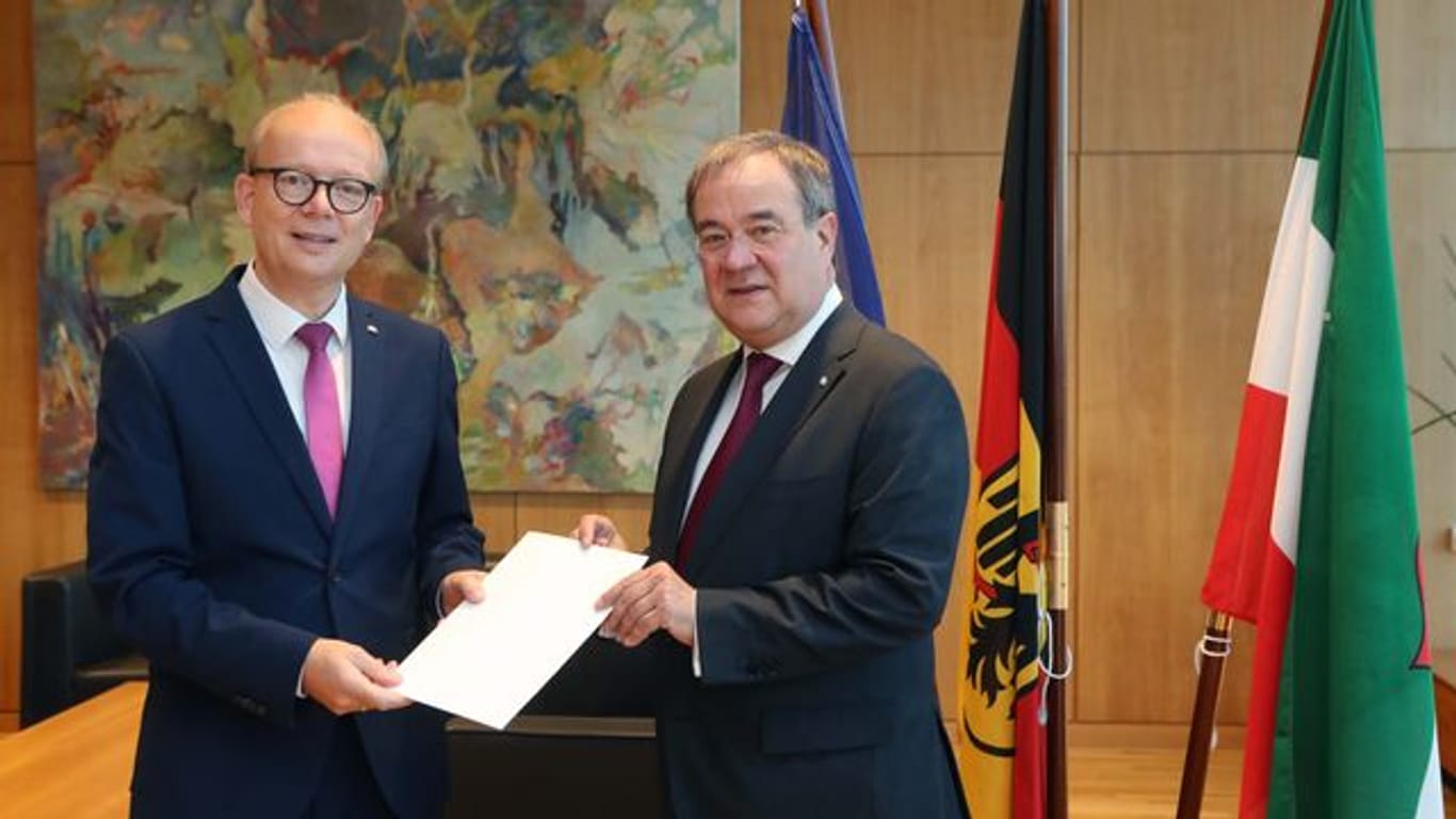 André Kuper (l) überreicht Armin Laschet die Urkunde über die Beendigung des Amtes als Ministerpräsident.