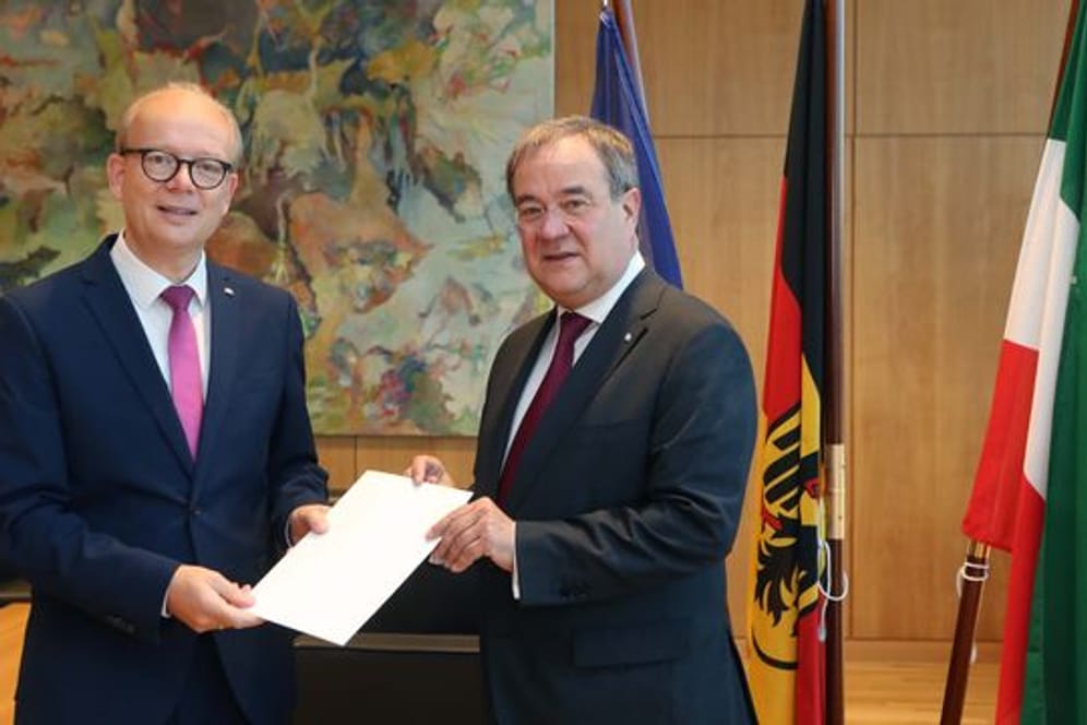 André Kuper (l) überreicht Armin Laschet die Urkunde über die Beendigung des Amtes als Ministerpräsident.