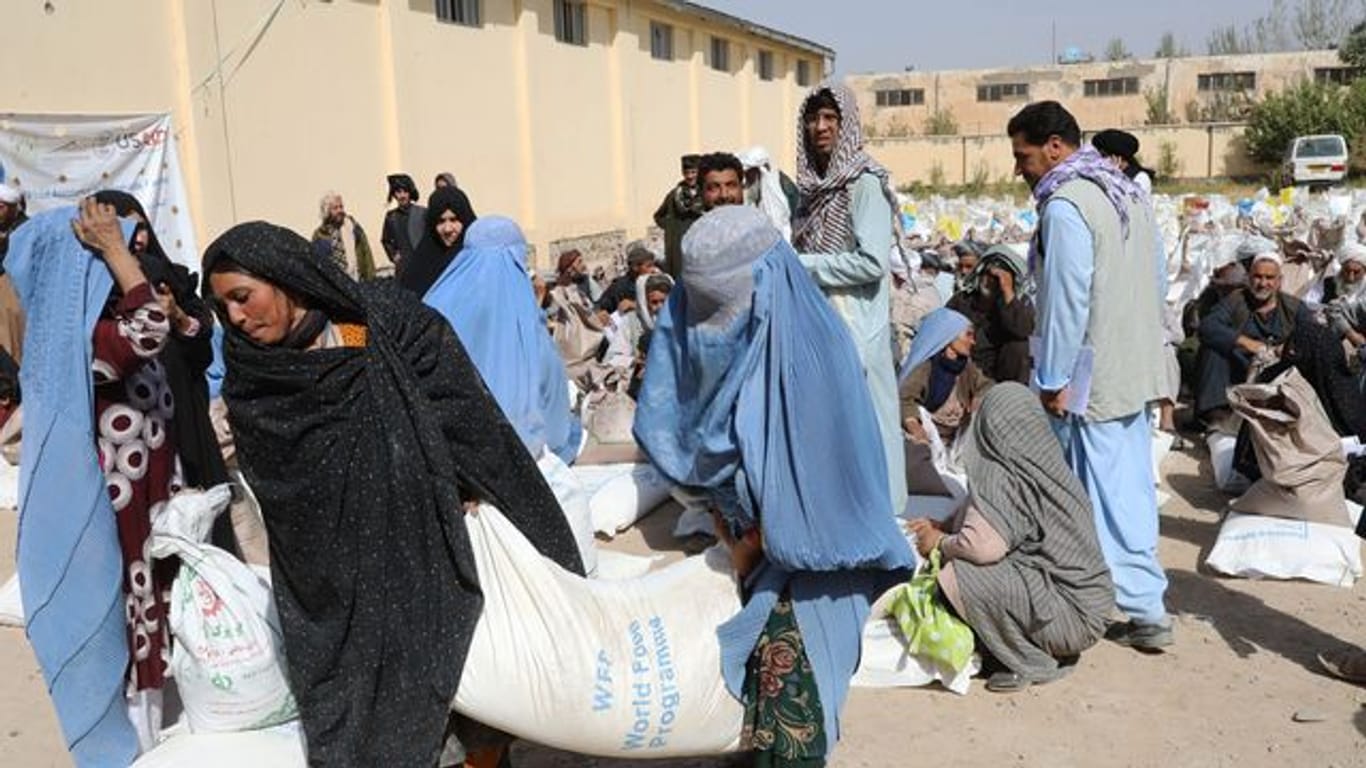 Frauen verlassen eine Verteilungsstelle des Welternährungsprogramm WFP am Stadtrand von Herat mit Lebensmittelrationen.