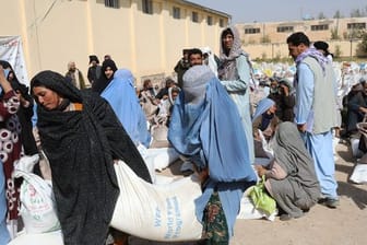 Frauen verlassen eine Verteilungsstelle des Welternährungsprogramm WFP am Stadtrand von Herat mit Lebensmittelrationen.