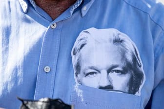 Ein Demonstrationsteilnehmer mit einer Maske des Wikileaks-Gründers Julian Assange im Hemd (Archivbild).