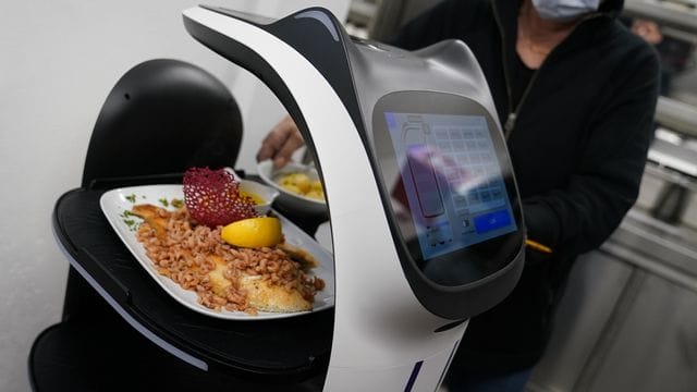 Der Servierroboter "Bella" wird in der Küche des Restaurants in Grömitz mit Gerichten für die Gäste beladen. Der Servierroboter "Bella" wird in der Küche des Restaurants in Grömitz mit Gerichten für die Gäste beladen.