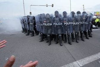 Polizisten rücken in Saquisili gegen Demonstranten vor.