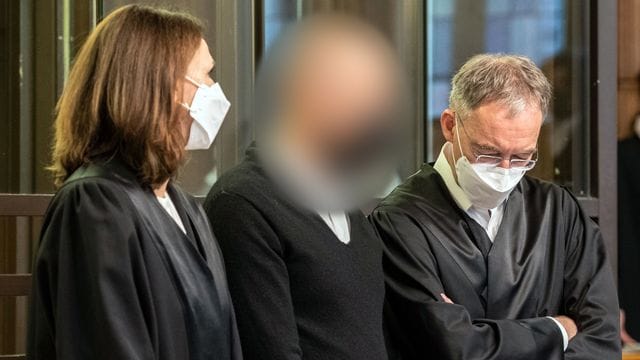 Der Angeklagte (M) zwischen seinen Anwälten in Berlin.