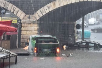 Fahrzeuge stehen auf einer überschwemmten Straße in Catania.