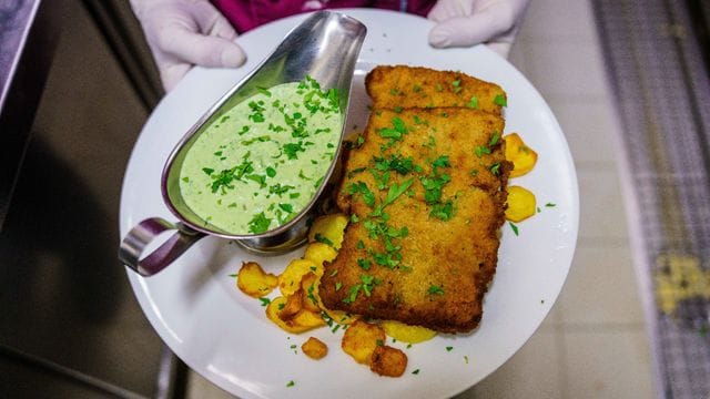 Ein veganes "Frankfurter Schnitzel" liegt frisch angerichtet auf dem Teller.