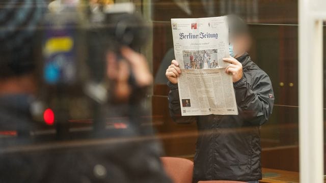 Der Angeklagte hält sich eine Zeitung vors Gesicht, während er zum Prozessbeginn in den Gerichtssaal im Berliner Kammergericht kommt. Der Angeklagte hält sich eine Zeitung vors Gesicht, während er zum Prozessbeginn in den Gerichtssaal im Berliner Kammergericht kommt.