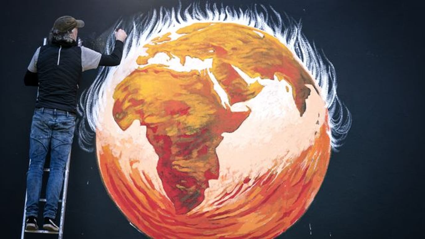 Anlässlich der UN-Klimakonferenz COP26 in Glasgow vollendet Künstler Greg Mitchell sein Wandgemälde zur Klimakrise.