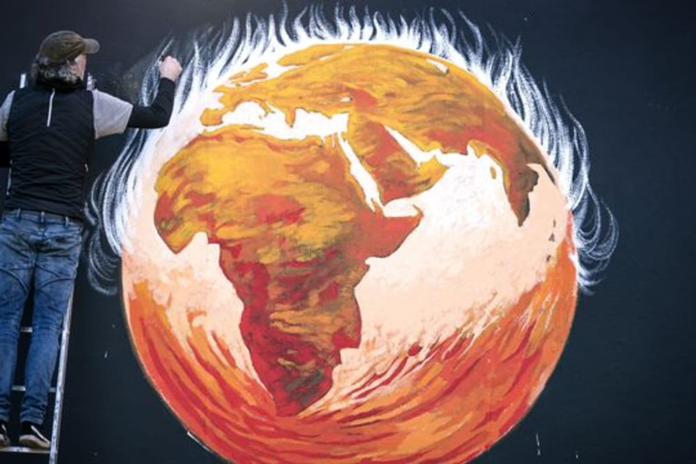 Anlässlich der UN-Klimakonferenz COP26 in Glasgow vollendet Künstler Greg Mitchell sein Wandgemälde zur Klimakrise.