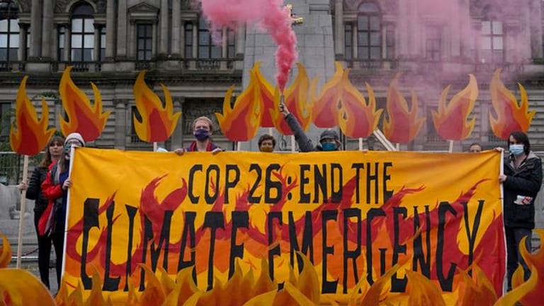 Klimaaktivisten haben den George Square in Glasgow vor der Weltklimakonferenz mit einer Kunstinstallation aus künstlichen Flammen, Rauch, Bannern und riesigen Feuerlöschern "in Brand gesetzt".