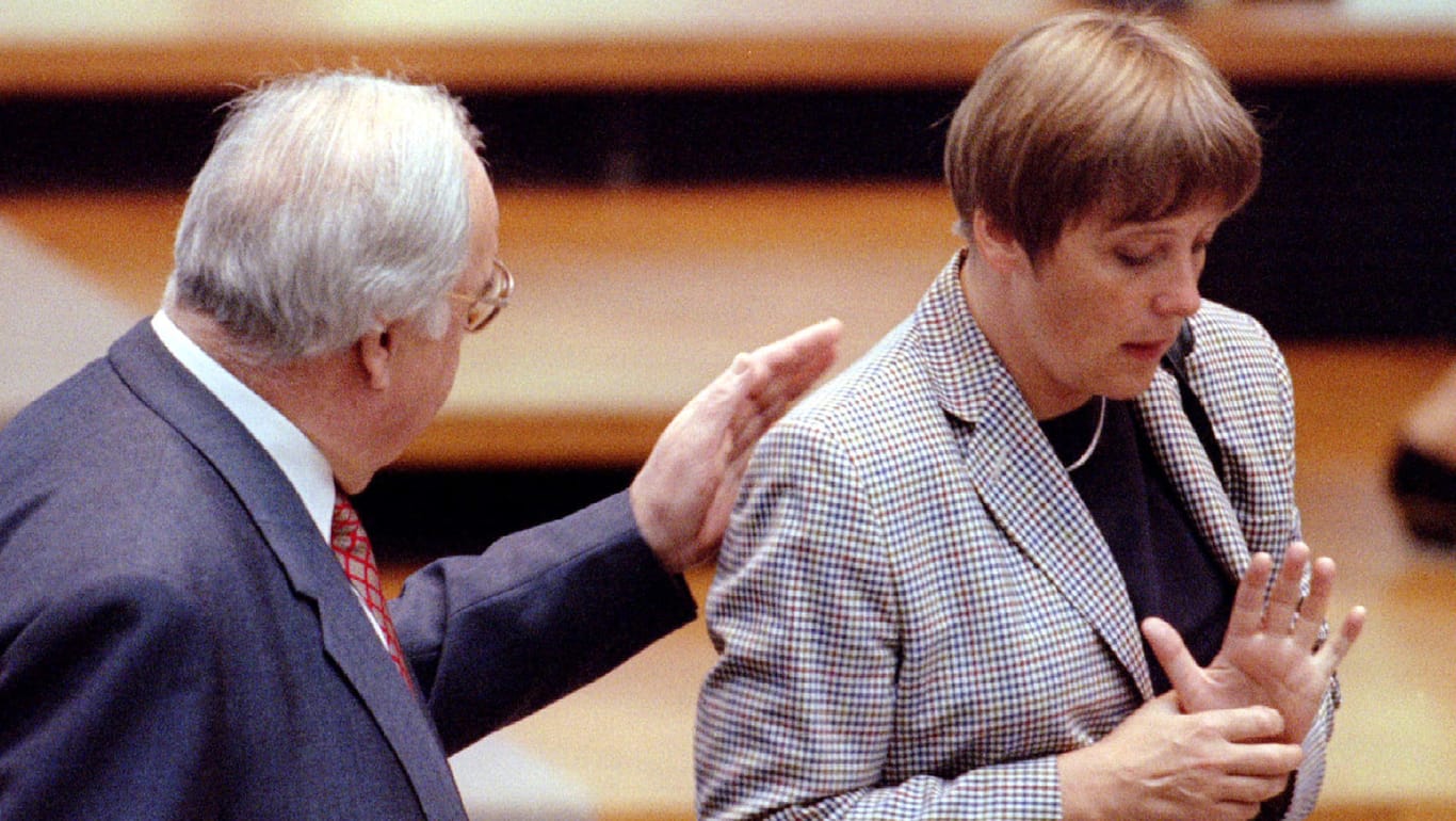 German Chancellor Helmut Kohl (L) gives a pat on the back of Environmental Minister Angela Merkel (R..