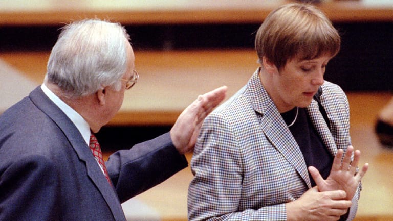 German Chancellor Helmut Kohl (L) gives a pat on the back of Environmental Minister Angela Merkel (R..