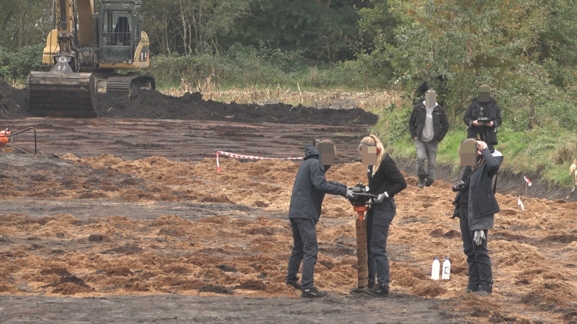 Beamte drehen einen Bohrer ins Erdreich, zuvor hat ein Bagger Erde weggeschaufelt: In der vergangenen Woche hat die Polizei auf einem Feld bei Posthausen nach einer männlichen Leiche gesucht.