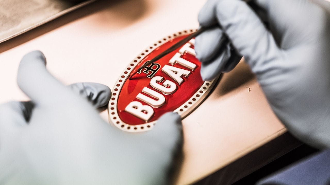 Logo, Hand anlegen: Ein Emblem für den Bugatti Chiron entsteht mit manueller Hilfe. Logo, Hand anlegen: Ein Emblem für den Bugatti Chiron entsteht mit manueller Hilfe.